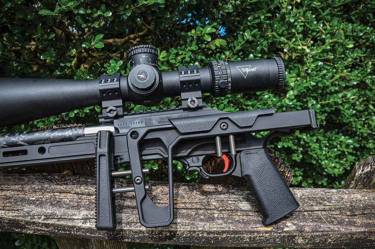 To release the hinge of the stock for folding to the left-hand side, grasp the stock with one hand and the frame with the other hand, with both hands positioned close to the hinge of the stock, then push up on the frame while pulling down on the stock,. Doing so shortens the overall length to 26.5 inches with the muzzle brake attached and 25 inches with it removed.